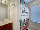 Well-lit bathroom with a vanity, sink, and Disney-themed shower curtain at 2530 Holtrock St, Kissimmee, FL 34747