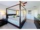 Comfortable primary bedroom features a four-poster bed, ceiling fan, and neutral decor at 2530 Holtrock St, Kissimmee, FL 34747