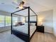 Bright primary bedroom boasts a four-poster bed, ceiling fan and window with blinds at 2530 Holtrock St, Kissimmee, FL 34747