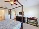 Comfortable primary bedroom features a four-poster bed and a dresser with a television at 2530 Holtrock St, Kissimmee, FL 34747