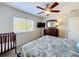Bright bedroom with ceiling fan, TV, dresser, window, bed and crib at 2530 Holtrock St, Kissimmee, FL 34747