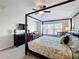 Bright primary bedroom boasts a four-poster bed, ceiling fan, crib and window with blinds at 2530 Holtrock St, Kissimmee, FL 34747