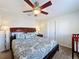 Spacious bedroom with ceiling fan, bed with patterned comforter, lamp, and crib at 2530 Holtrock St, Kissimmee, FL 34747