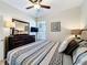 Well-lit bedroom featuring a dresser with a mirror and a TV, along with a window for natural light at 2530 Holtrock St, Kissimmee, FL 34747