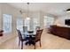 Dining area with a round glass table, four chairs, and access to the pool area at 2530 Holtrock St, Kissimmee, FL 34747