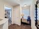 Bright hallway with door to bedroom and home office space with chair, desk, and window view at 2530 Holtrock St, Kissimmee, FL 34747