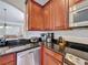 Kitchen area featuring stainless steel appliances, dark granite counters, and wooden cabinetry at 2530 Holtrock St, Kissimmee, FL 34747