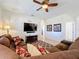 Cozy living room featuring a large sectional sofa, a ceiling fan, and a flat-screen TV at 2530 Holtrock St, Kissimmee, FL 34747
