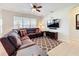 Relaxing living room featuring a sectional sofa, ceiling fan, and wall-mounted television at 2530 Holtrock St, Kissimmee, FL 34747