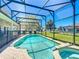 Relax by the in-ground pool and spa, all within a screened enclosure and large backyard at 2530 Holtrock St, Kissimmee, FL 34747