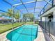Outdoor oasis with a large screened-in pool, spa, and a well-maintained backyard at 2530 Holtrock St, Kissimmee, FL 34747