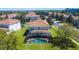 Aerial view of a home with a screened-in pool, featuring a tile roof and green lawn at 2530 Holtrock St, Kissimmee, FL 34747
