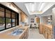 Bright kitchen with a sink, window overlooking the pool, stainless steel appliances, and a view of the dining room at 25548 Pine Valley Dr, Mount Plymouth, FL 32776