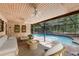Enclosed brick patio with swimming pool, ceiling fans, seating, and tropical greenery at 25548 Pine Valley Dr, Mount Plymouth, FL 32776
