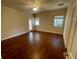 A spacious bedroom with dark wood-look flooring and natural light from three windows at 25721 Pinehurst St, Sorrento, FL 32776