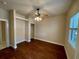 This bedroom features sleek wood floors, a ceiling fan, closet space, and natural light from the window at 25721 Pinehurst St, Sorrento, FL 32776