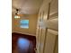 This bedroom features sleek wood floors, a ceiling fan and natural light from the window at 25721 Pinehurst St, Sorrento, FL 32776