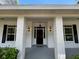 Charming front entrance features a black door, sidelights, sconces and classic columns at 25721 Pinehurst St, Sorrento, FL 32776