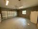 Spacious garage featuring painted concrete block walls, updated flooring and door at 25721 Pinehurst St, Sorrento, FL 32776