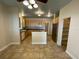 Bright kitchen featuring tile floors, stainless steel appliances, and light wood cabinets with black countertops at 25721 Pinehurst St, Sorrento, FL 32776