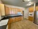 Kitchen with light cabinetry, black countertops, a stainless fridge, and tiled floors at 25721 Pinehurst St, Sorrento, FL 32776