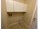 Bright laundry room featuring tile flooring, white cabinets, and a door to the exterior at 25721 Pinehurst St, Sorrento, FL 32776