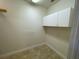 Bright laundry room with tiled flooring, white cabinets, and neutral paint at 25721 Pinehurst St, Sorrento, FL 32776