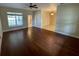 Spacious living room with dark wood-look tile flooring, a ceiling fan, and natural light from a bright window at 25721 Pinehurst St, Sorrento, FL 32776