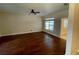 Neutral living room featuring hardwood floors, ceiling fan, and a window with green views at 25721 Pinehurst St, Sorrento, FL 32776