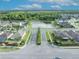 Overhead aerial view of a neighborhood entrance with lush greenery, serene pond, and cozy residential houses at 2607 Quail Pond Way, Kissimmee, FL 34743