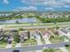 Aerial view of neighborhood homes, showing a pond, and street in a residential area with blue skies at 2607 Quail Pond Way, Kissimmee, FL 34743