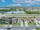 Aerial view of neighborhood homes, showing a pond, and street in a residential area with blue skies at 2607 Quail Pond Way, Kissimmee, FL 34743