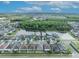 An aerial view of neighborhood homes near a pond, surrounded by many trees and vegetation at 2607 Quail Pond Way, Kissimmee, FL 34743