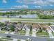 Aerial view of neighborhood homes, showing a pond, and street in a residential area with blue skies at 2607 Quail Pond Way, Kissimmee, FL 34743