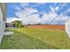 Well-maintained back yard with expansive lawn, brick fence, and a distant screened-in lanai at 2607 Quail Pond Way, Kissimmee, FL 34743