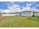 Back yard featuring manicured lawn, white vinyl fence, and patio doors at 2607 Quail Pond Way, Kissimmee, FL 34743