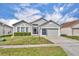 Charming single-story home features a well-maintained lawn and a two-car garage at 2607 Quail Pond Way, Kissimmee, FL 34743