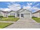 Charming single-story home features a well-maintained lawn and a two-car garage at 2607 Quail Pond Way, Kissimmee, FL 34743
