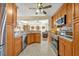 The open kitchen has wood cabinets, granite countertops, stainless appliances, and bar seating at 2607 Quail Pond Way, Kissimmee, FL 34743
