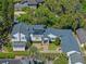 Aerial view of a beautiful home with a dark roof, brick driveway, and a lush backyard surrounded by trees at 266 Chase Ave, Winter Park, FL 32789