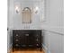 Classic bathroom with a black vanity, marble countertop, sconces, and paneled walls at 266 Chase Ave, Winter Park, FL 32789