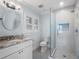 Well-lit bathroom features modern vanity, gray tile floors, round mirror, and glass-enclosed shower at 266 Chase Ave, Winter Park, FL 32789