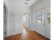 Bright hallway with hardwood floors, white paneled walls, and a front door view at 266 Chase Ave, Winter Park, FL 32789