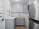 Well-lit kitchen featuring light blue cabinets, a stainless steel refrigerator, and a stainless steel sink at 266 Chase Ave, Winter Park, FL 32789