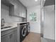 A spacious laundry room with gray cabinetry, stainless washer/dryer, and natural light at 266 Chase Ave, Winter Park, FL 32789