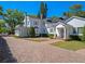 Rear exterior showcasing a beautiful home with meticulously maintained landscaping and a brick driveway at 266 Chase Ave, Winter Park, FL 32789