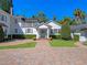 Rear exterior featuring a charming home with a brick driveway and meticulously maintained landscaping at 266 Chase Ave, Winter Park, FL 32789