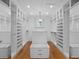 Bright, spacious walk-in closet with custom shelving, drawers, hardwood floors and a decorative chandelier at 266 Chase Ave, Winter Park, FL 32789