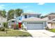 Charming two-story blue home featuring a front-facing two car garage and a vibrant red front door at 271 Morning Glory Dr, Lake Mary, FL 32746