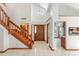 Grand foyer featuring tile floors, a wooden staircase, and a view into the adjacent kitchen at 271 Morning Glory Dr, Lake Mary, FL 32746